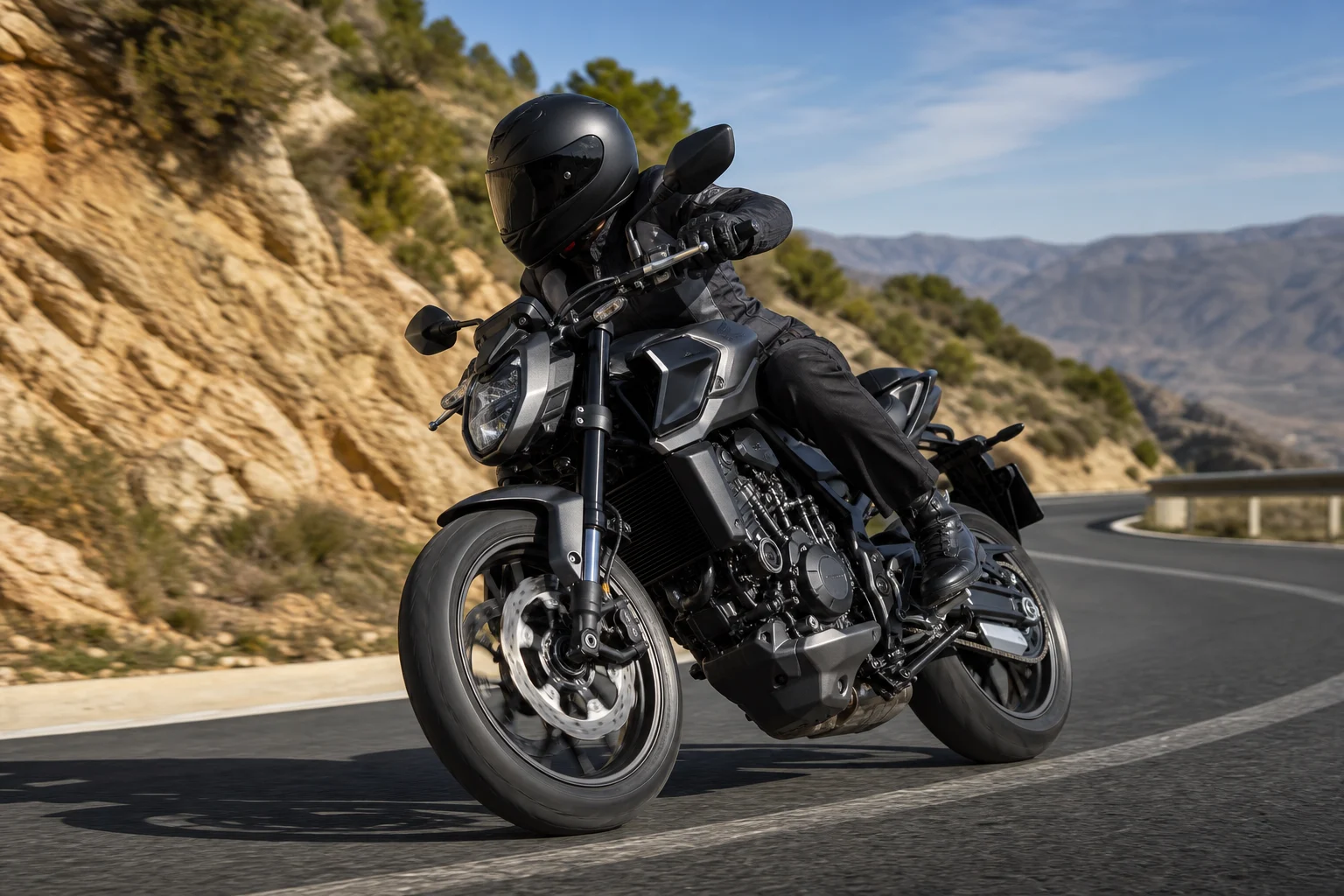 Motorcycle riding at a moderate lean through a paved bend, with the rider looking towards the exit